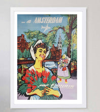 Load image into Gallery viewer, Vintage-style poster of a woman holding tulips with Amsterdam landmarks in the background.