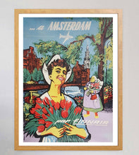 Load image into Gallery viewer, Vintage-style poster of a woman holding tulips with 'Amsterdam' text and wooden frame.