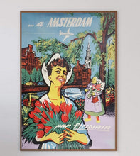 Load image into Gallery viewer, Vintage-style travel poster for Amsterdam featuring a woman with tulips and traditional architecture.