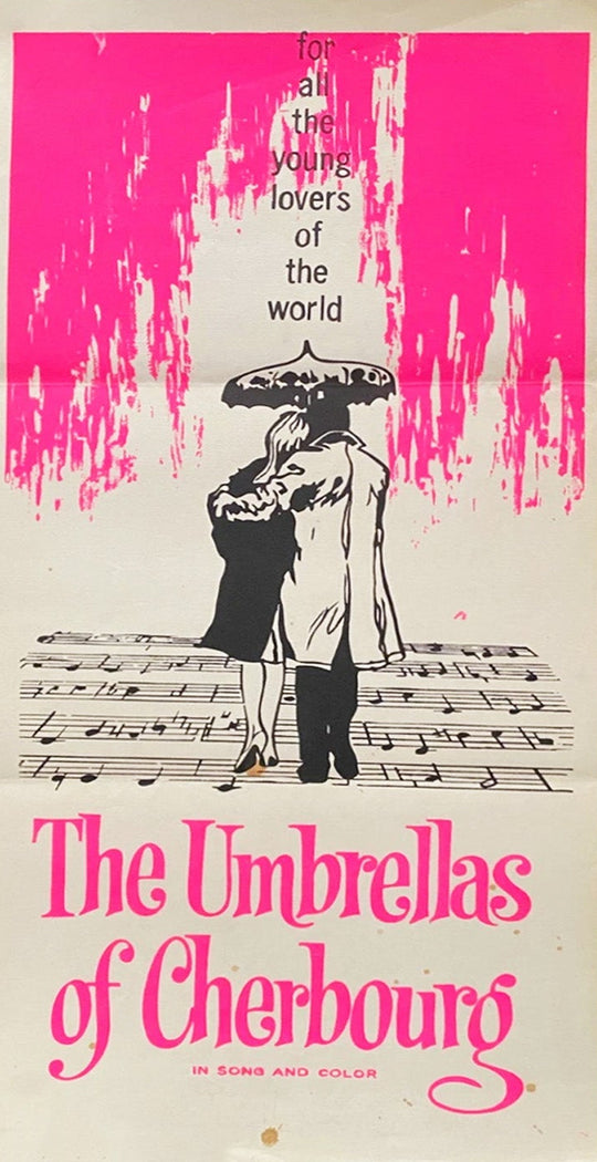 Poster for 'The Umbrellas of Cherbourg' with a couple under an umbrella and pink abstract design.