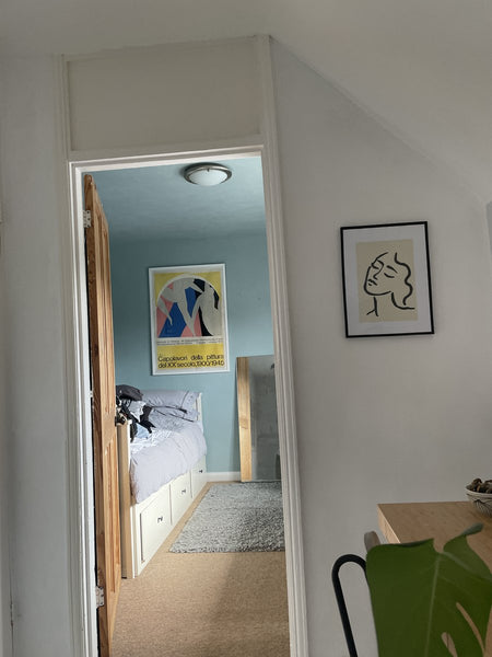 A framed print through the bedroom doorway