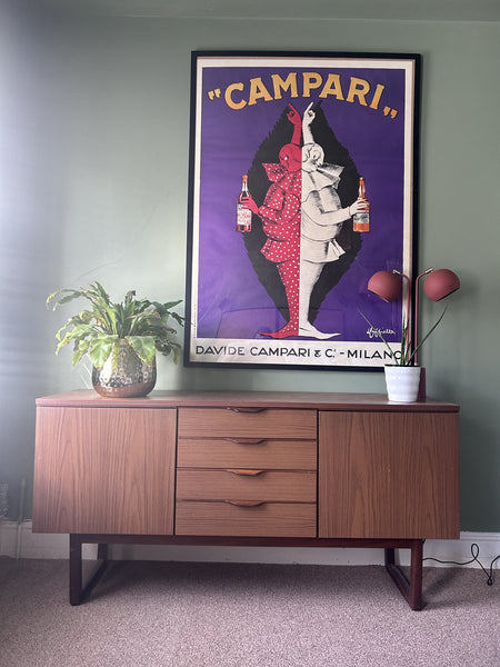 Campari poster above a sideboard