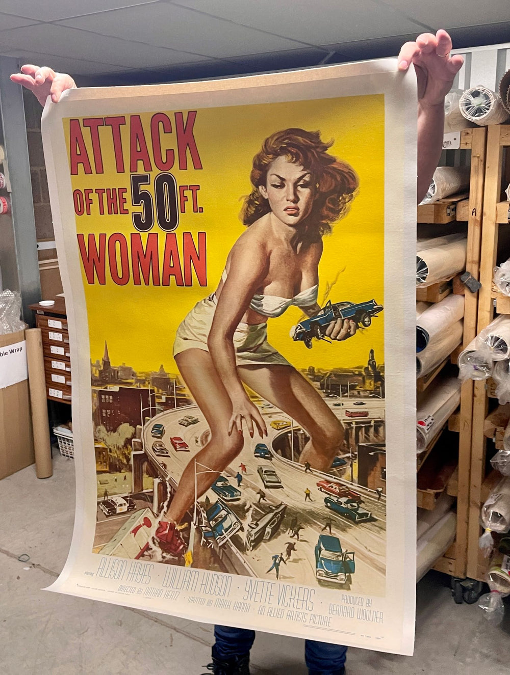 An original Attack of the 50 Ft. Woman poster held open, showing its period fold lines