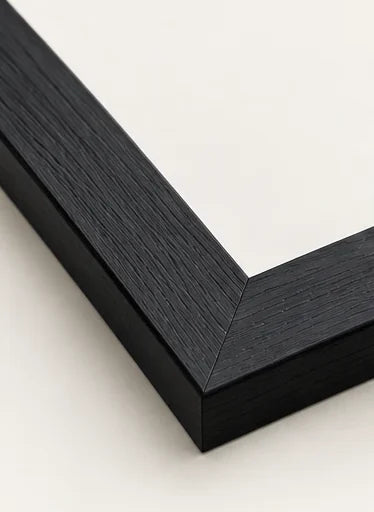 Mitred corner of our black moulding, showing the fine open grain under a matt finish