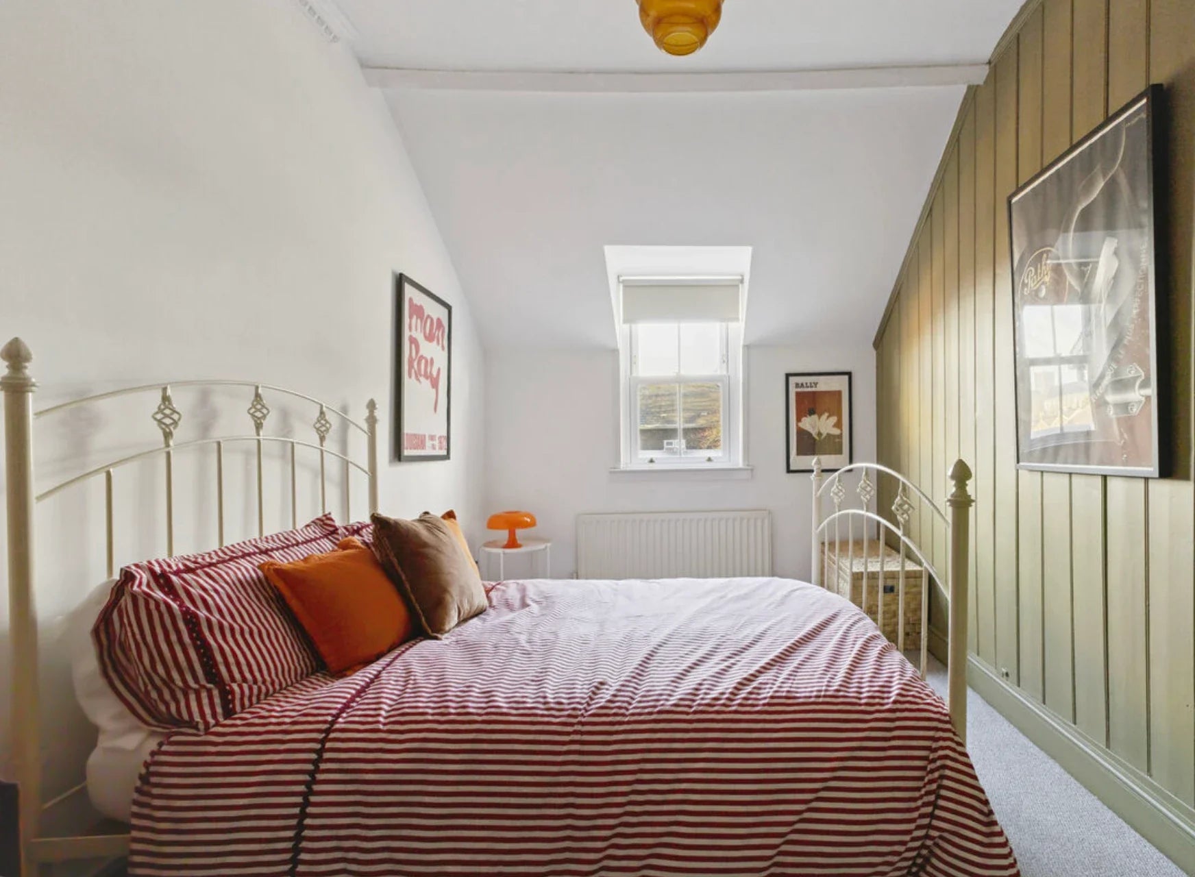 Original Man Ray, Bally and Path&eacute; posters framed in a bedroom with green panelling