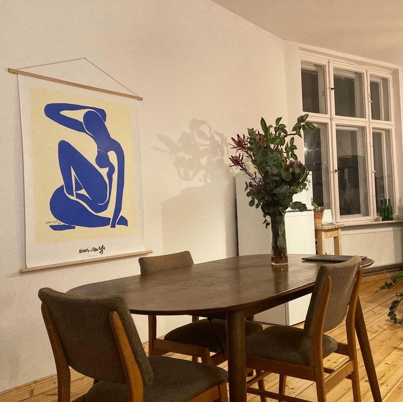 An original Henri Matisse Blue Nude poster hanging above a dining table