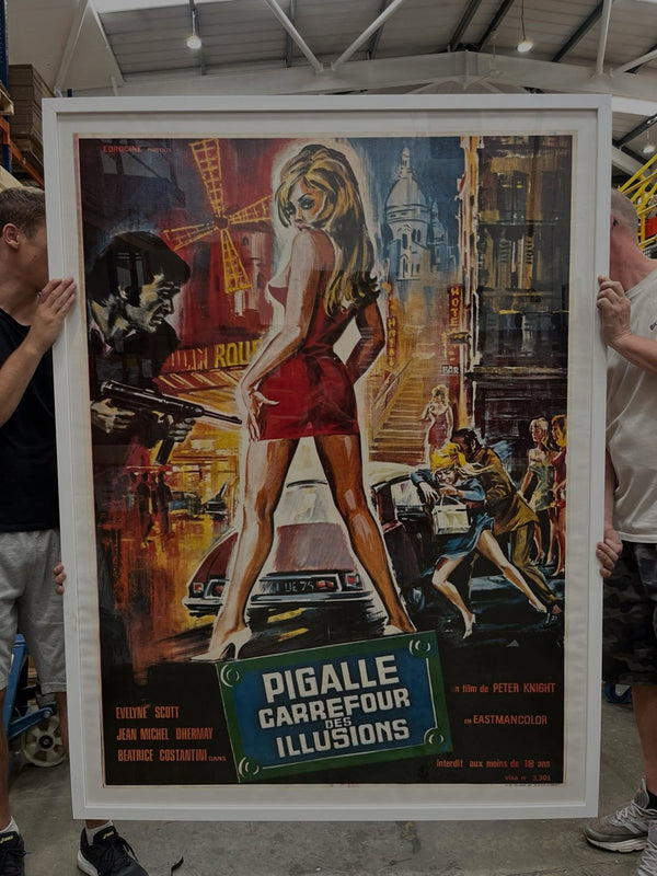 An original Pigalle Carrefour des Illusions poster held up, fresh out of the frame shop